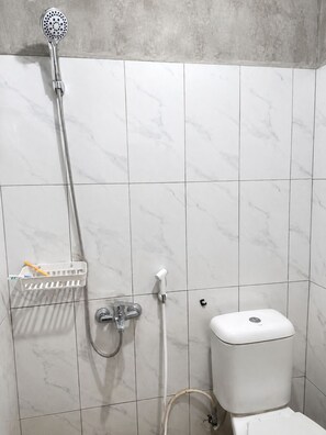 Ein Badezimmer mit Dusche, Toilette und Waschbecken.