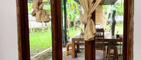 A room with a view of an outdoor area, including a table and chairs.