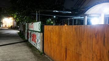 Una entrada protegida por un muro de madera y una pared con grafitis.