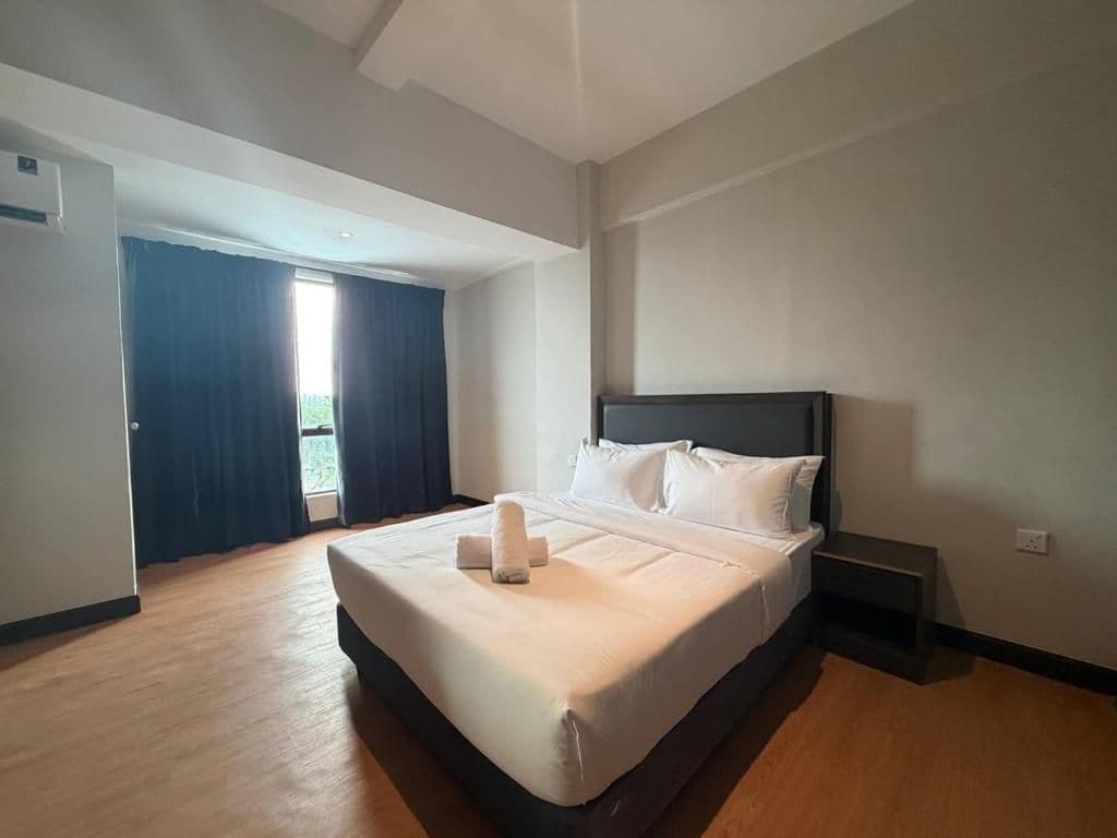 Une chambre d’hôtel avec un grand lit, une table de chevet et une vue sur l’extérieur par une fenêtre.