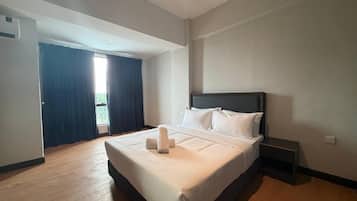 Une chambre d’hôtel avec un grand lit, une table de chevet et une vue sur l’extérieur par une fenêtre.