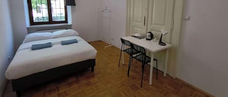 A room with a bed, a desk, a chair, and a wardrobe.