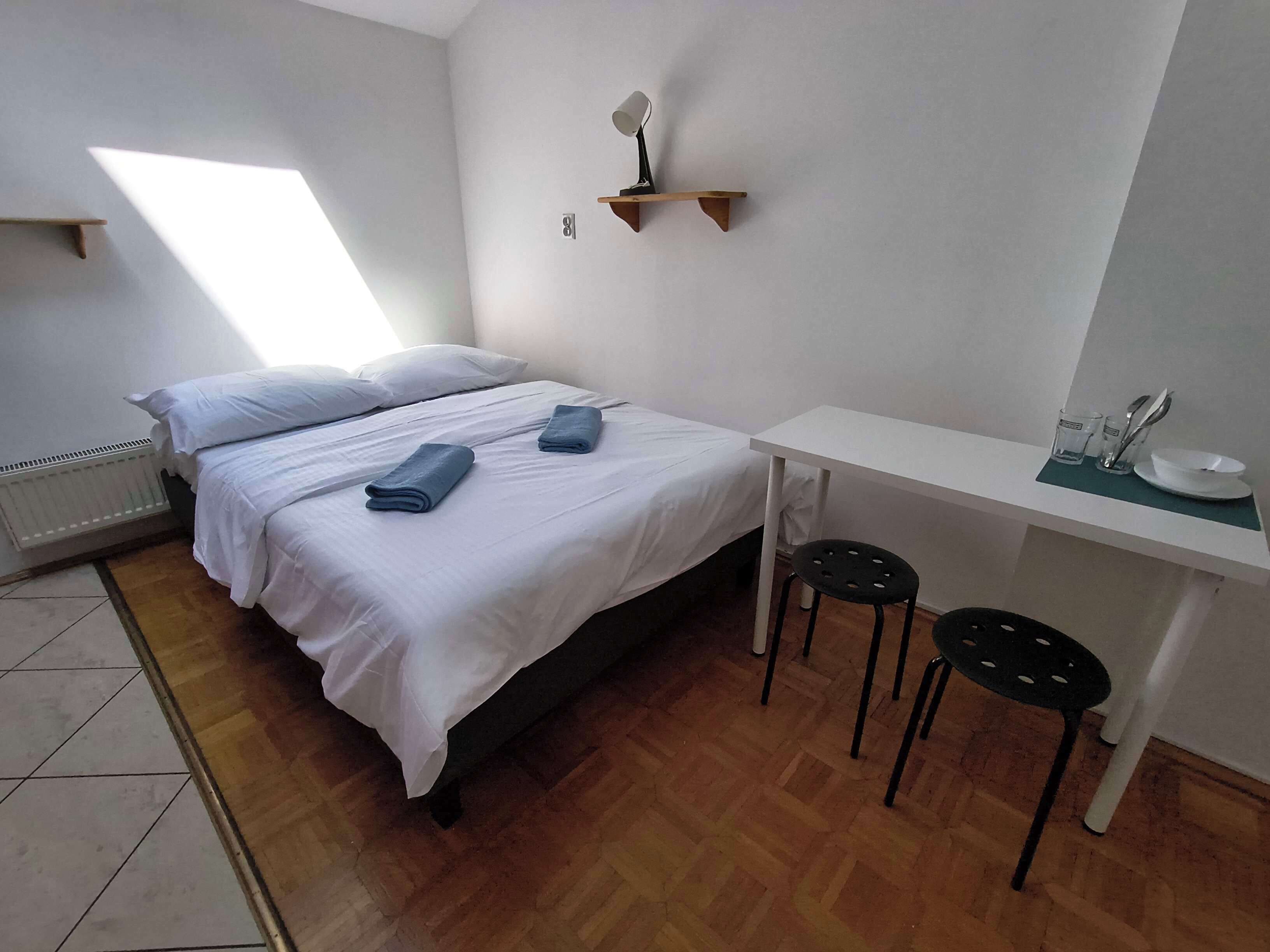 A room with two beds, a desk, and a chair.