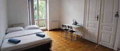 Un dormitorio con cama, escritorio y armario.