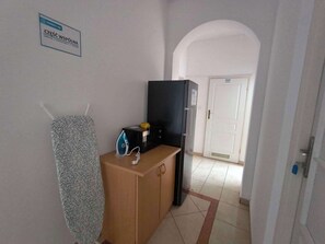 Une chambre d’hôtel équipée d’une kitchenette, d’un réfrigérateur, d’un four à micro-ondes et d’un porte-serviettes.