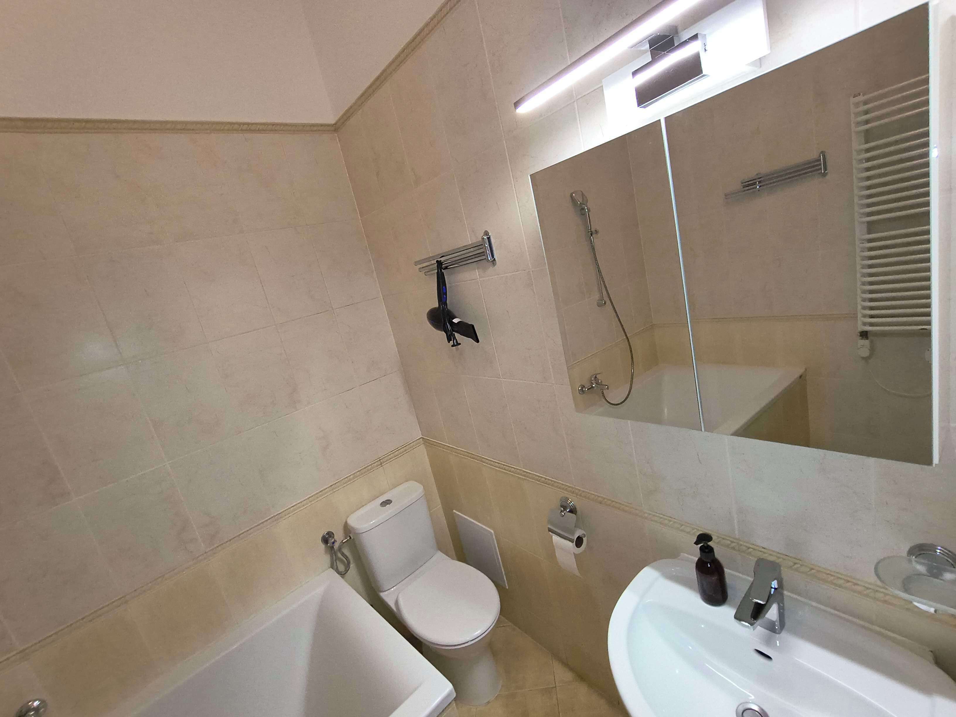 A bathroom with a bathtub, toilet, and sink.
