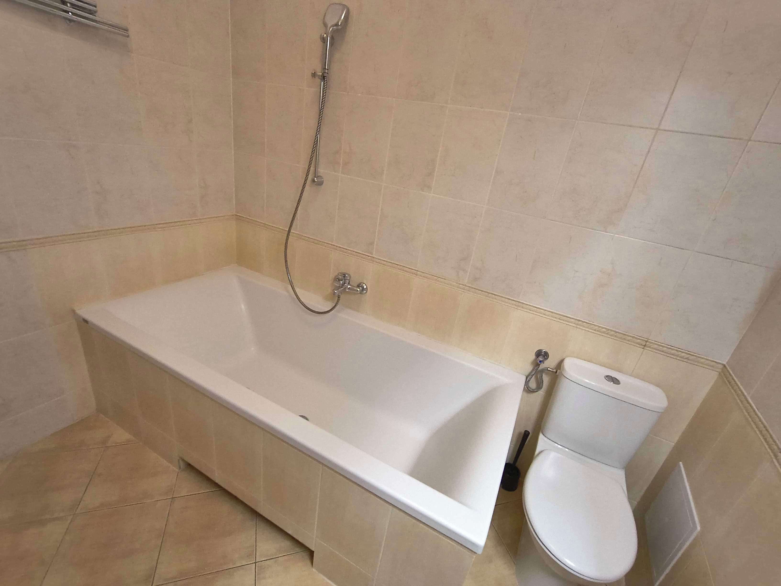 A bathroom with a bathtub, toilet, and shower.