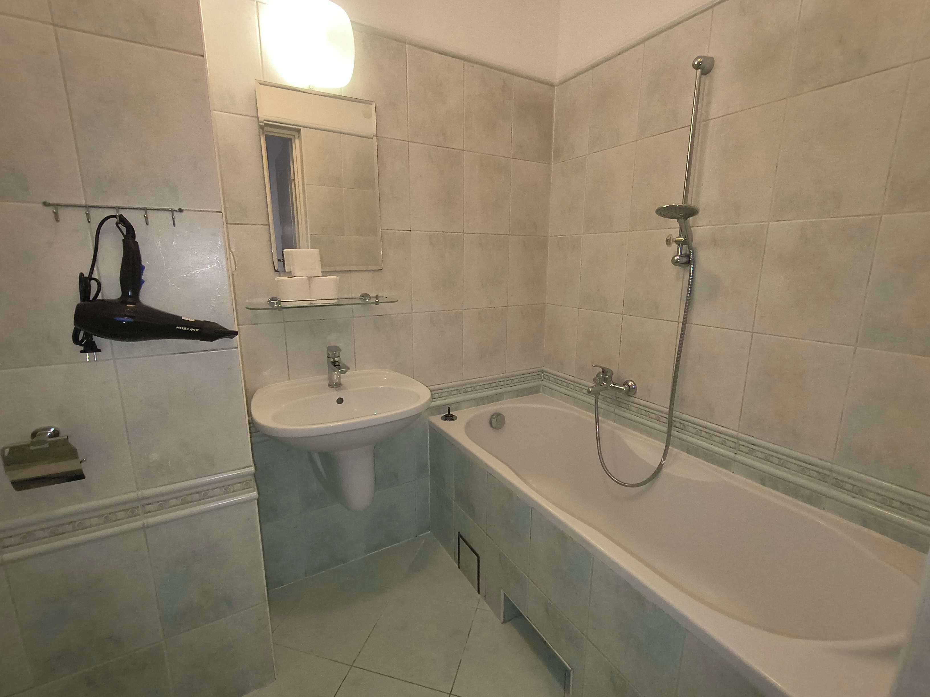 Ein Badezimmer mit Badewanne, Waschbecken und Dusche.