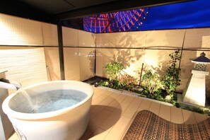 Ein Whirlpool in einer gefliesten Außenanlage mit Blick auf ein Riesenrad.