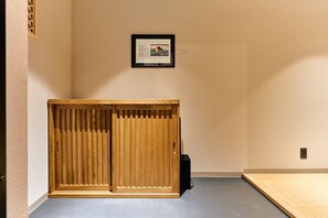 A room with a wooden wardrobe, a framed certificate on the wall, and a small black object on the floor. - Imakusa-so, Osaka, Tempozan - Tall Lantern - (大阪府大阪市港区築港3丁目)