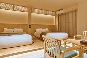 Una habitación de hotel con dos camas, un escritorio de madera y una silla.