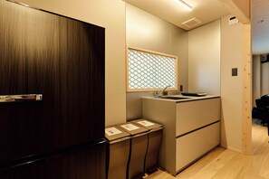 A compact kitchen with a sink, a small countertop, and a wooden door.