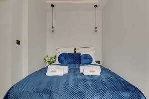 A hotel room with a bed, two hanging light fixtures, and a wall-mounted control panel. - Lawendowa Room Nº1 | Shared Kitchen | Old Town (Gdańsk)