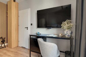 A modern room with a desk, chair, TV, and a decorative vase. - Lawendowa Room Nº5 | Shared Kitchen | Balcony (Gdańsk)