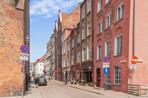Eine enge Straße gesäumt von historischen Gebäuden, einige mit Balkonen und Beschilderung, die Park- und Zufahrtsbeschränkungen kennzeichnet.