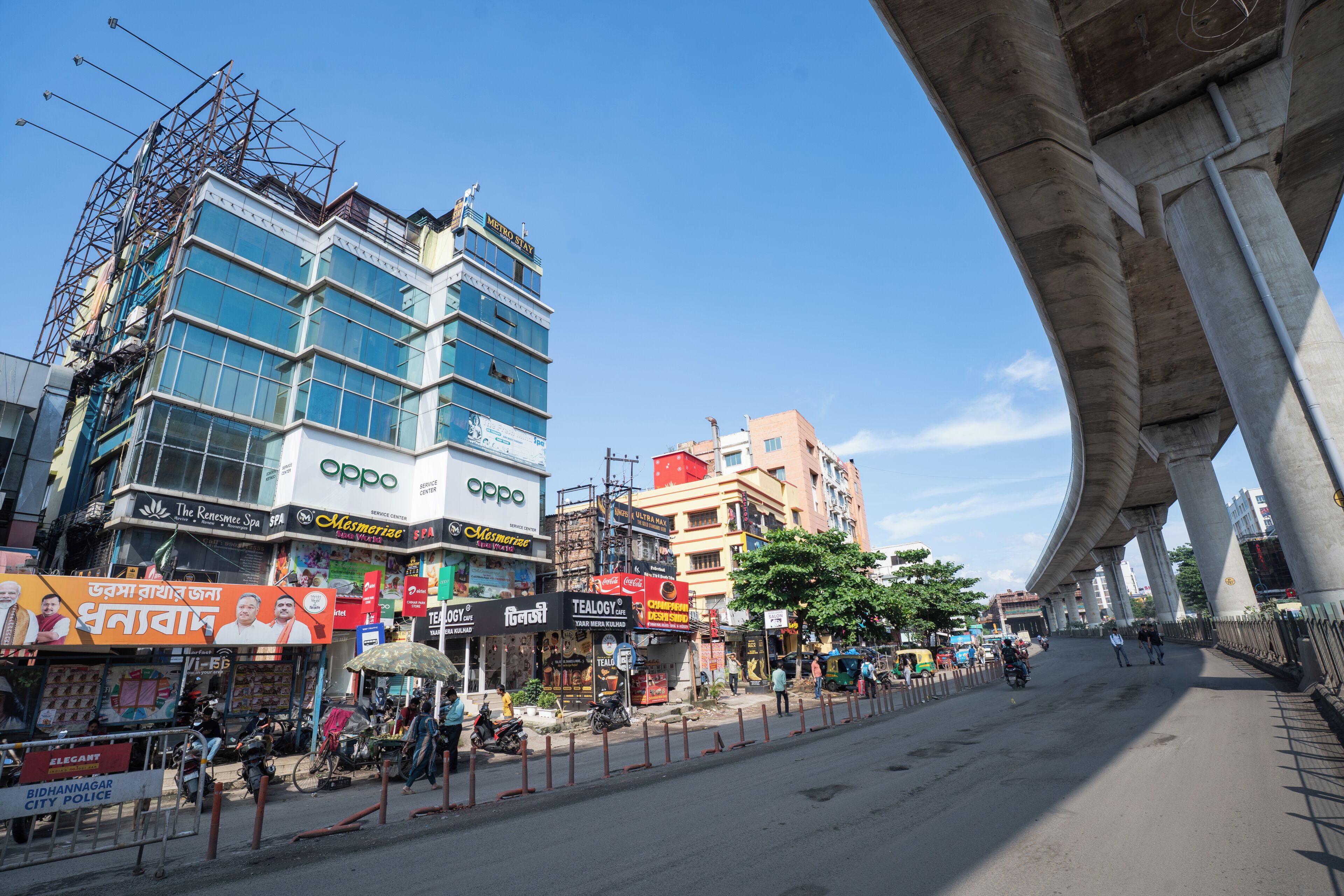 A multi-story building with commercial establishments on the ground floor, including a service center and a cafe.