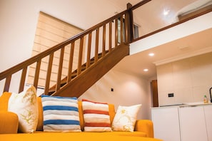 Una escalera con barandillas de madera que sube a un nivel superior.
