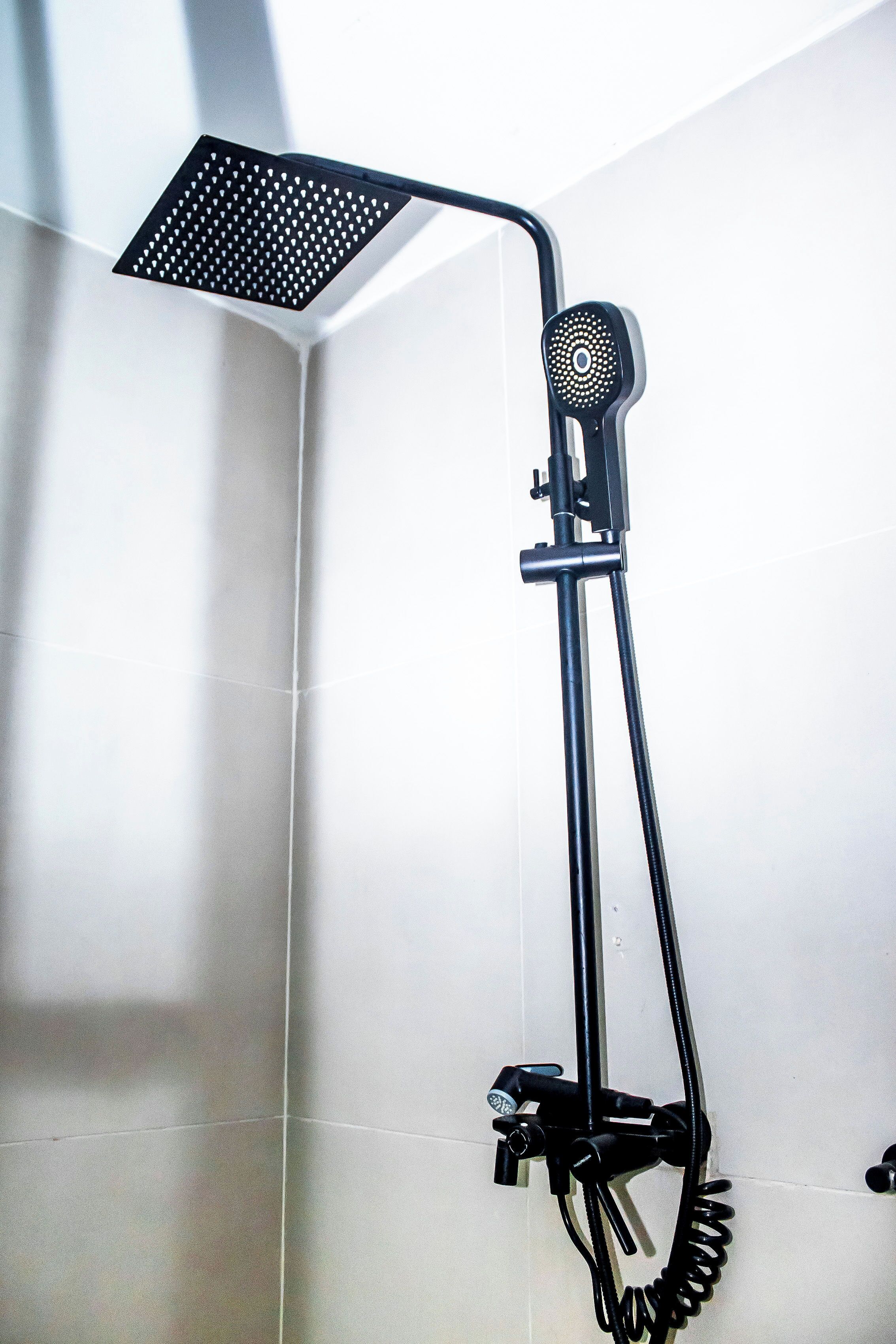 A shower with a handheld head and a flexible hose.