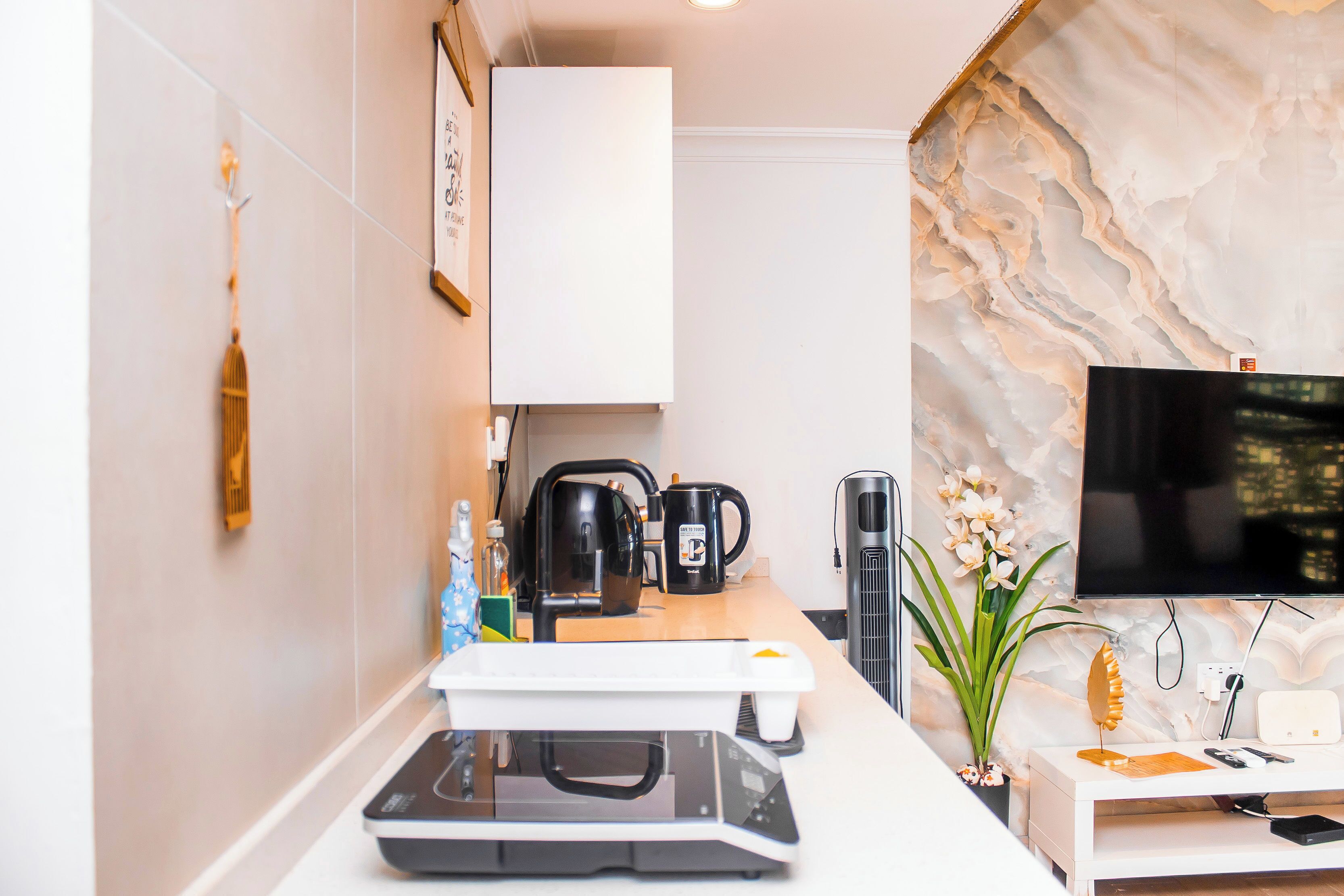 Una cocina moderna con cafetera, hervidor y microondas integrados.