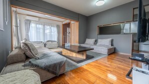 Uma sala de estar moderna com um sofá, uma mesa de centro e uma televisão.