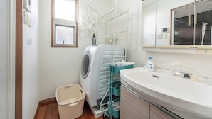 Uma casa de banho moderna com máquina de lavar embutida, uma pia e um espelho.