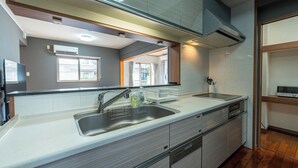 Uma cozinha moderna com pia de aço inoxidável, forno embutido e máquina de lavar louça.