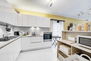 A modern kitchen with white cabinets, a built-in oven, a microwave, and a coffee maker. - Emotion Lake Lugano With Direct Lake Access and Shared Pool (Mendrisio)