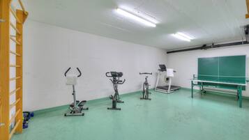 A gym with exercise equipment including a treadmill, stationary bike, and elliptical.