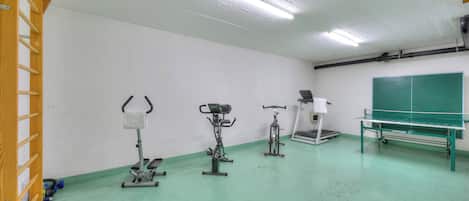 A gym with exercise equipment including a treadmill, stationary bike, and elliptical.