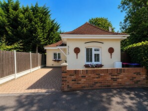 A single-story house with a brick facade, a tiled roof, and a number '313' on the wall.
