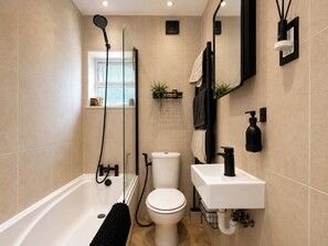 A modern bathroom with a bathtub, toilet, and sink.