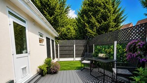 Una terraza con un tapete de diseño blanco y negro, una mesa y dos sillas.