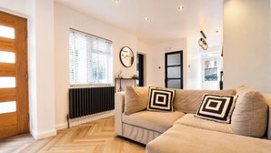 Una sala de estar moderna con un conjunto de sofá, un radiador y piso de madera.