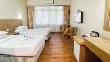 Een hotelkamer met twee bedden, een bureau, een stoel en een televisietoestel.