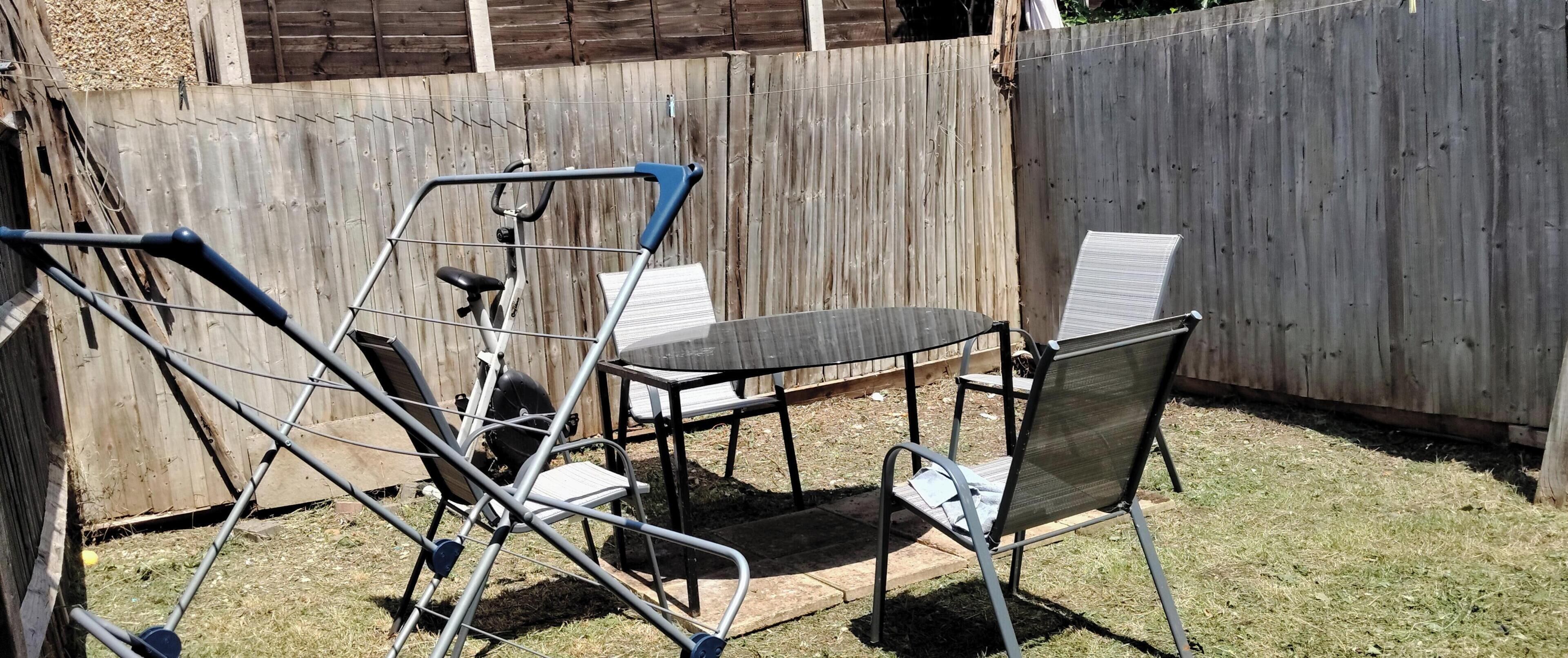 A patio area with a metal chair, a table, and a bicycle.