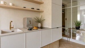 A modern kitchen with a built-in espresso machine, a sink, and a countertop with a plant and a croissant. - The Secret Escape - Close to the Beach (Sopot)