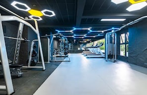 A gym with various exercise equipment, including treadmills and weight machines, and a central walking path. - Takdiri Homes Neptune (Nairobi)