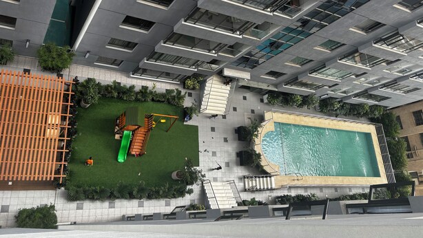 A high-rise building with a rooftop pool and a children's play area. - Takdiri Homes Neptune (Nairobi)