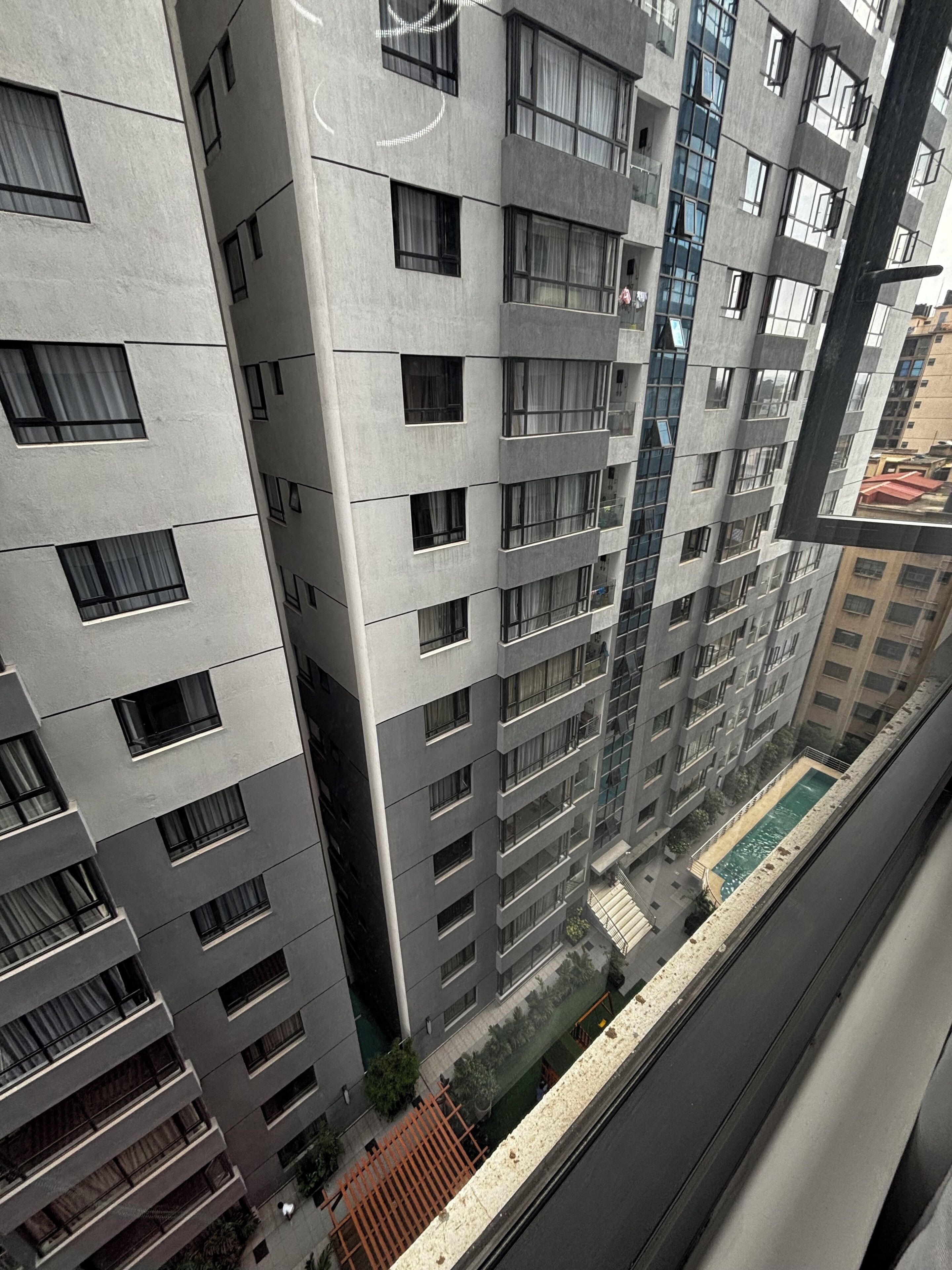 Un edificio de gran altura con varios balcones y una piscina.