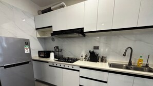 A modern kitchen with stainless steel appliances, a gas stove, and a sink. - Takdiri Homes Neptune (Nairobi)