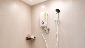 Ducha con cabezal de ducha de mano y panel de control en la pared.