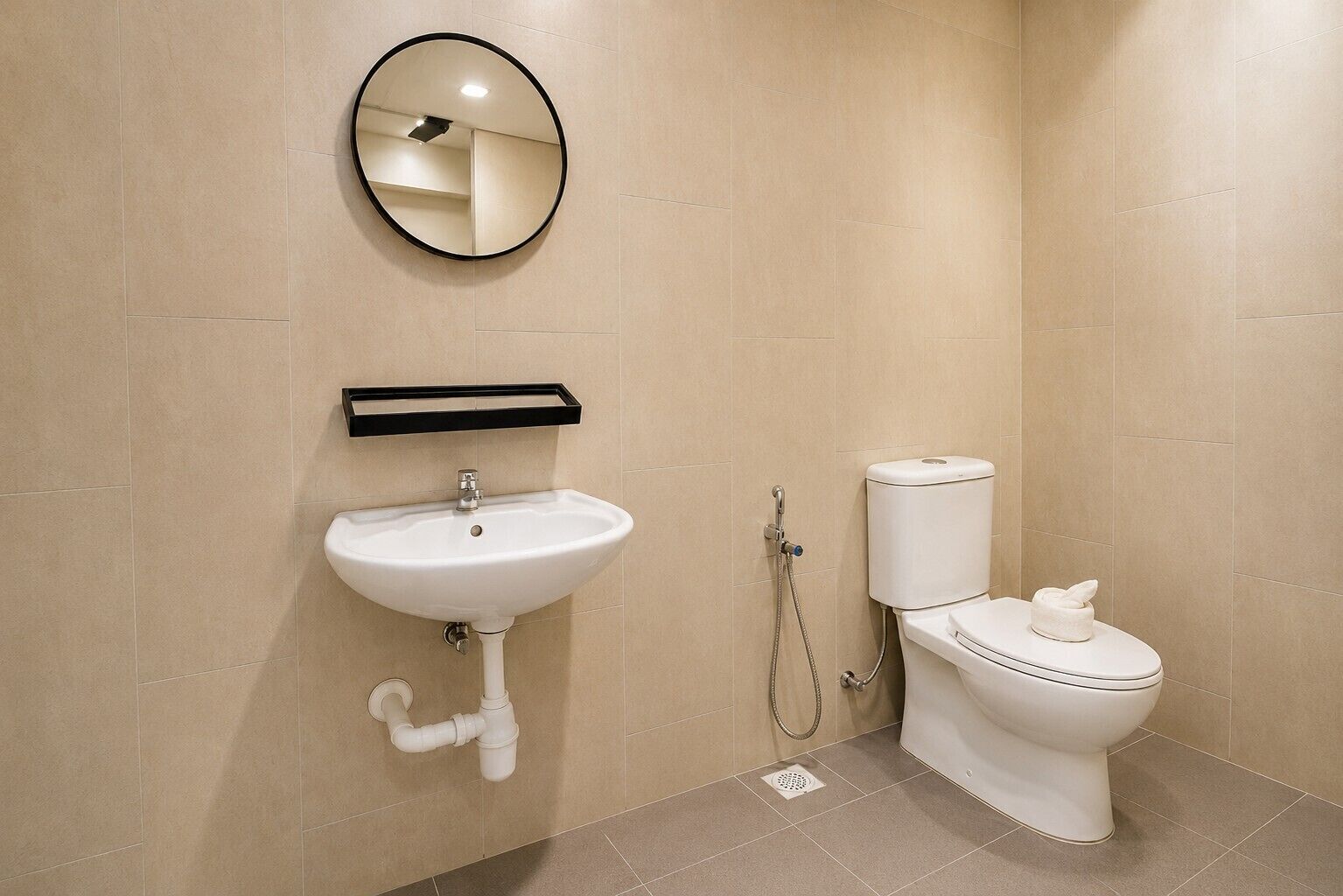 A bathroom with a white sink, a toilet, and a mirror on the wall.