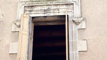 A doorway with a decorative lintel and a partially open wooden door.