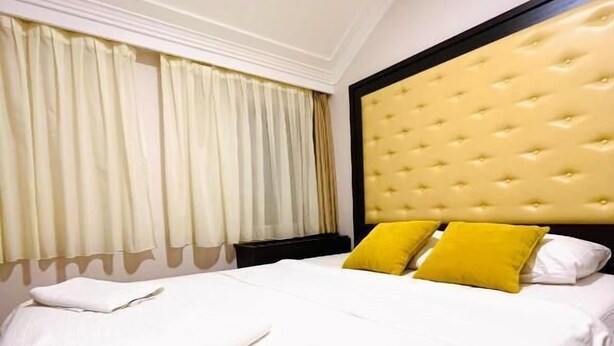 A hotel room with a bed, curtains, and a headboard. - Swiss Holiday Hotel by Kundakcı Group (Rafajlovici)