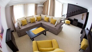 A living room with a sectional sofa, a yellow armchair, and a coffee table. - Swiss Holiday Hotel by Kundakcı Group (Rafajlovici)