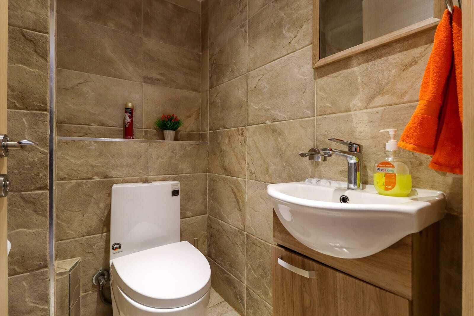 Une salle de bain avec des toilettes, un lavabo et une douche.