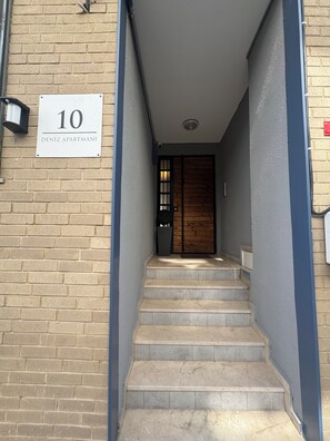 A staircase leading to a wooden door with a sign above indicating the apartment number 10. - Stylish apartment with a separate bedroom near Taksim with AC (Istanbul)