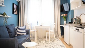 A compact living space with a sofa, a dining table, and a kitchen area. - Stylish apartment with a separate bedroom near Taksim with AC (Istanbul)
