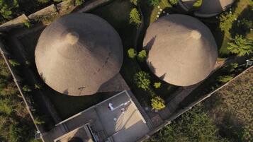Luchtbeeld van een binnenplaats met twee grote ronde constructies, een geplaveid pad en omliggend groen.