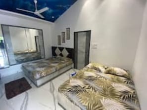 Ein Schlafzimmer mit einem Bett, einem Deckenventilator und einem großen Spiegel.